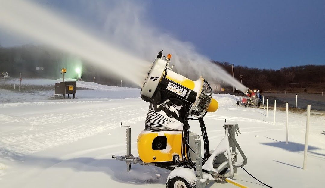 Seven Oaks in USA - a snow blower is spraying snow on the ground.