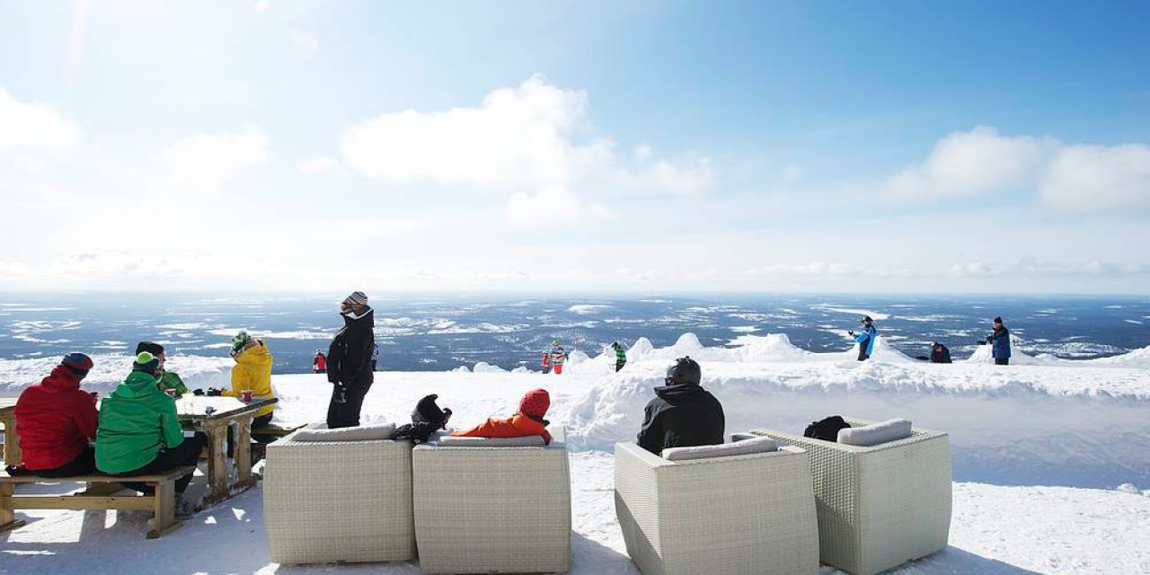 Ylläs in Finland - a group of people sitting on top of a mountain.