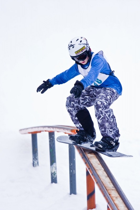 A snowboarder carving through fresh powder at Shanty Creek Resorts - Summit Mountain in Michigan USA. A beautiful winter scene displaying the thrill of snowboarding.