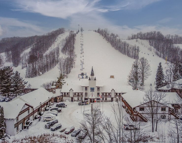 View of Summit Mountain ski resort in Michigan, featuring a ski lift against a backdrop of vast wintry landscape, inviting winter sports enthusiasts.