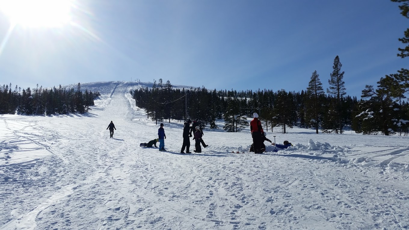 Näsfjället in Sweden - a group of people skiing down a snow covered mountain.