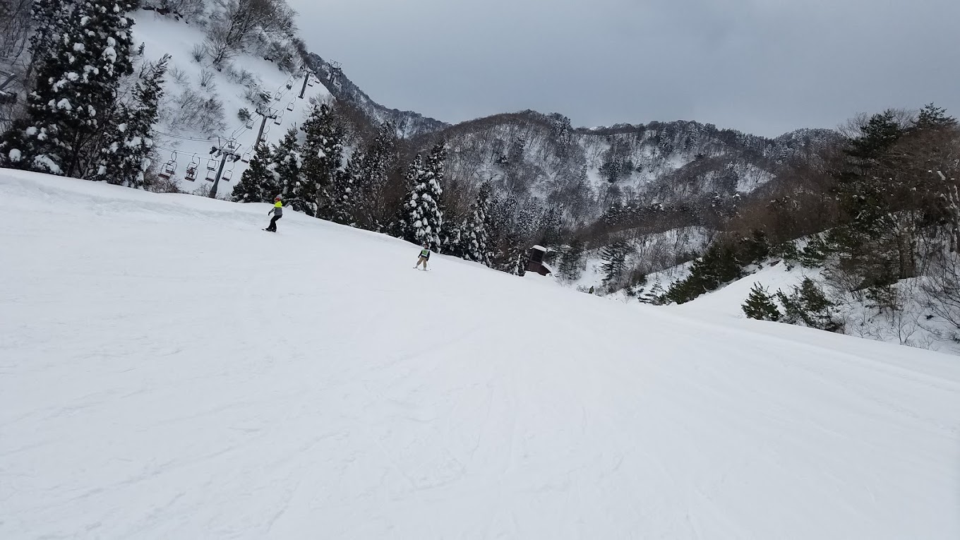Kunizakai Kogen Snow Park in Japan - a person skiing down a snow covered slope.
