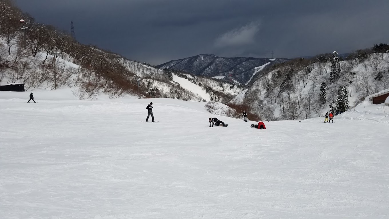 Kunizakai Kogen Snow Park in Japan - a group of people riding down a snow covered slope.