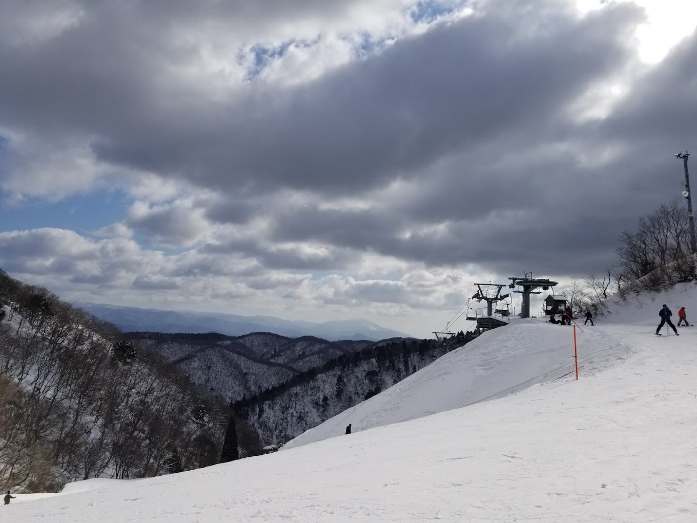 Kunizakai Kogen Snow Park in Japan - a group of people skiing down a snow covered mountain.