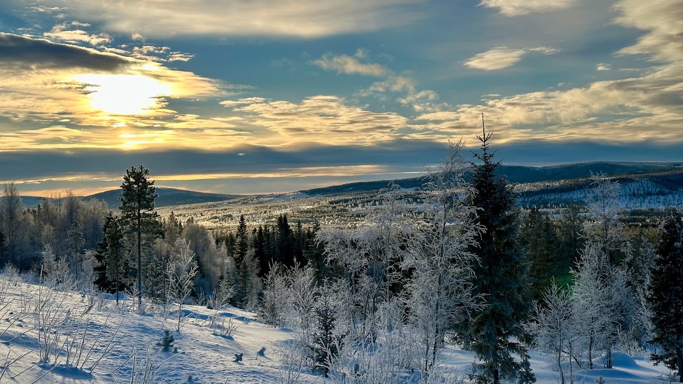 Fulufjellet in Norway - the sun is shining through the clouds over a snowy landscape.