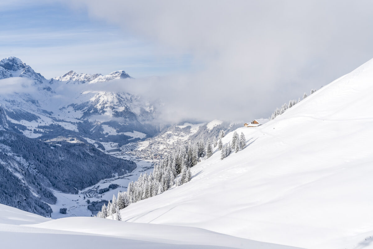 Rinderberg | ​Saanerslochgrat | ​Horneggli – Zweisimmen | ​Saanenmöser | ​Schönried | ​St Stephan in Switzerland - a person skiing down a snow covered mountain.