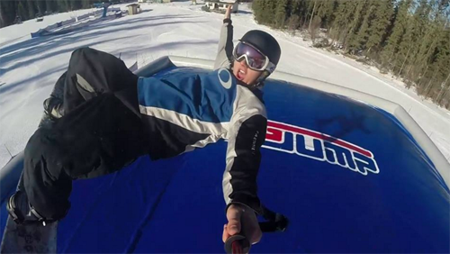 A skier and a snowboarder in action at Vista Ridge Northern Alberta Canada. They are surrounded by an enchanting winter sports scene complete with a ski lift and the stunning vista of the ski resort.