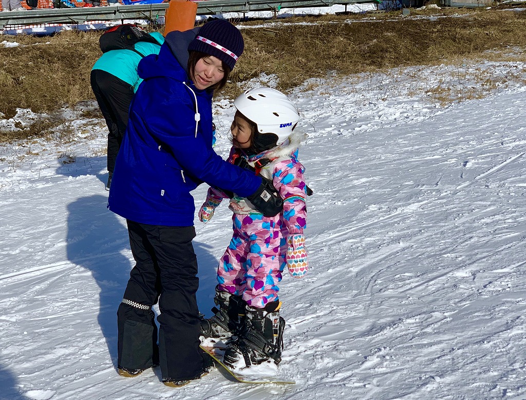 Yachiho Kogen in Japan - a man and a little girl on a snowboard.