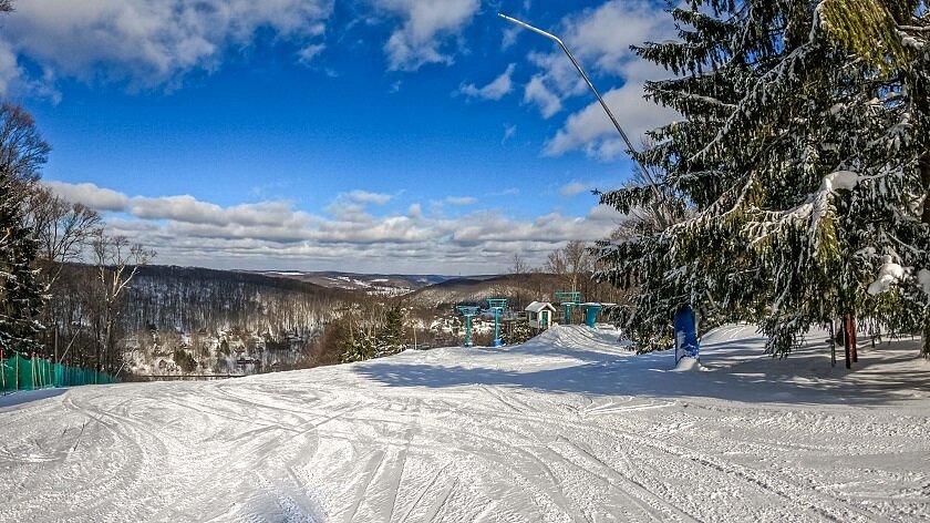 Holiday Mountain -NY in USA - a snow covered ski slope with trees in the background.