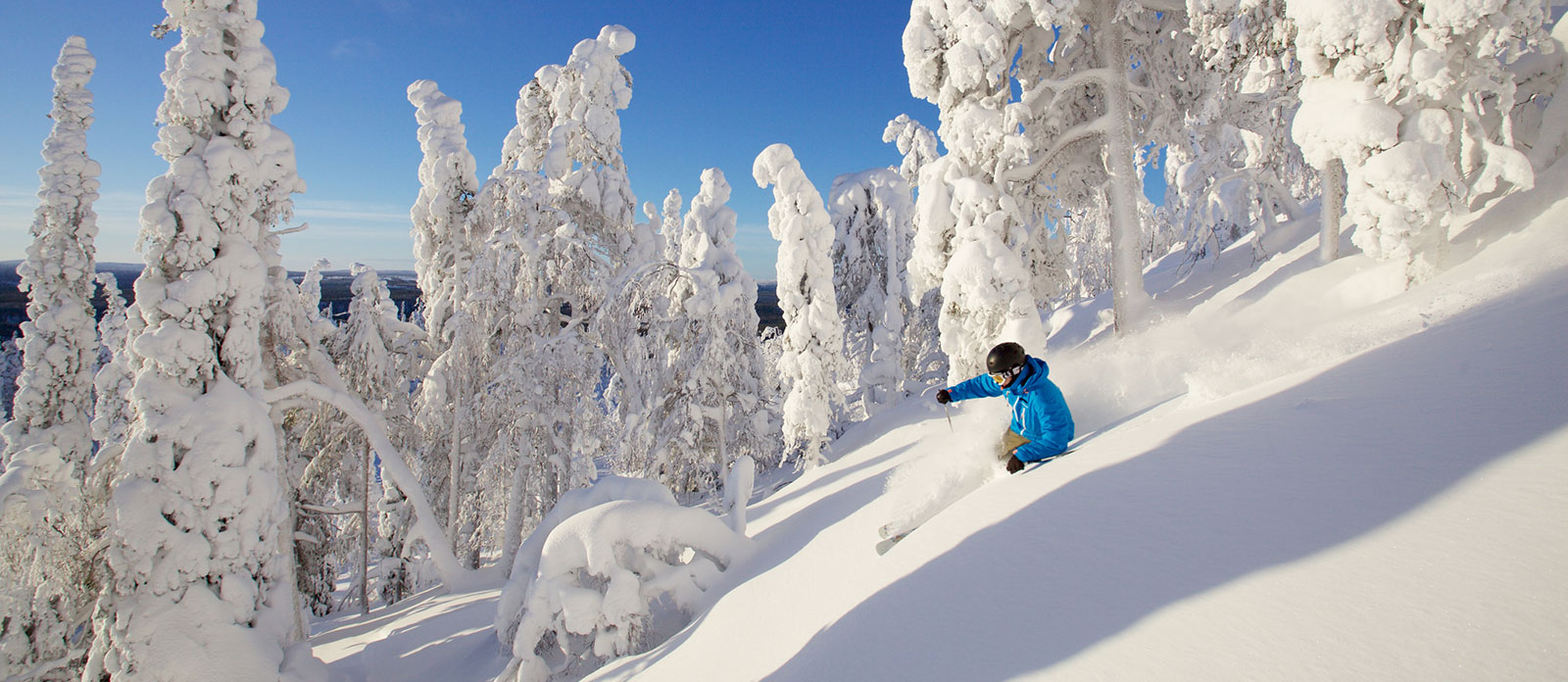 Salla in Finland - a person riding a snowboard down a snowy slope.