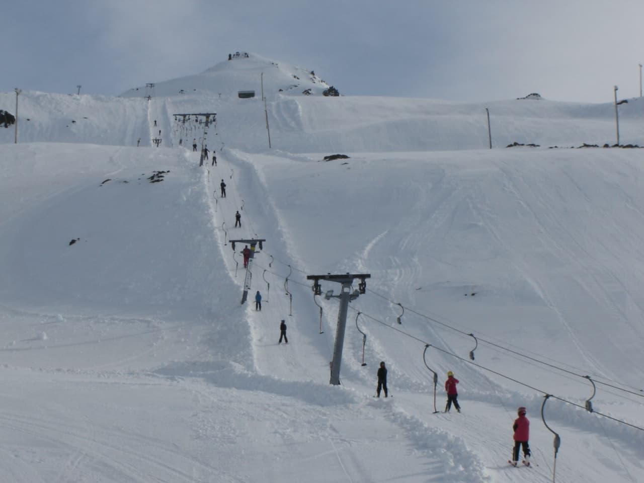 Oddsskarð in Iceland - a group of people skiing down a snowy slope.
