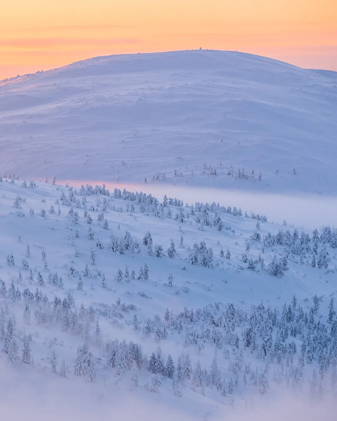 Pyhä in Finland - a mountain covered in snow at sunrise.