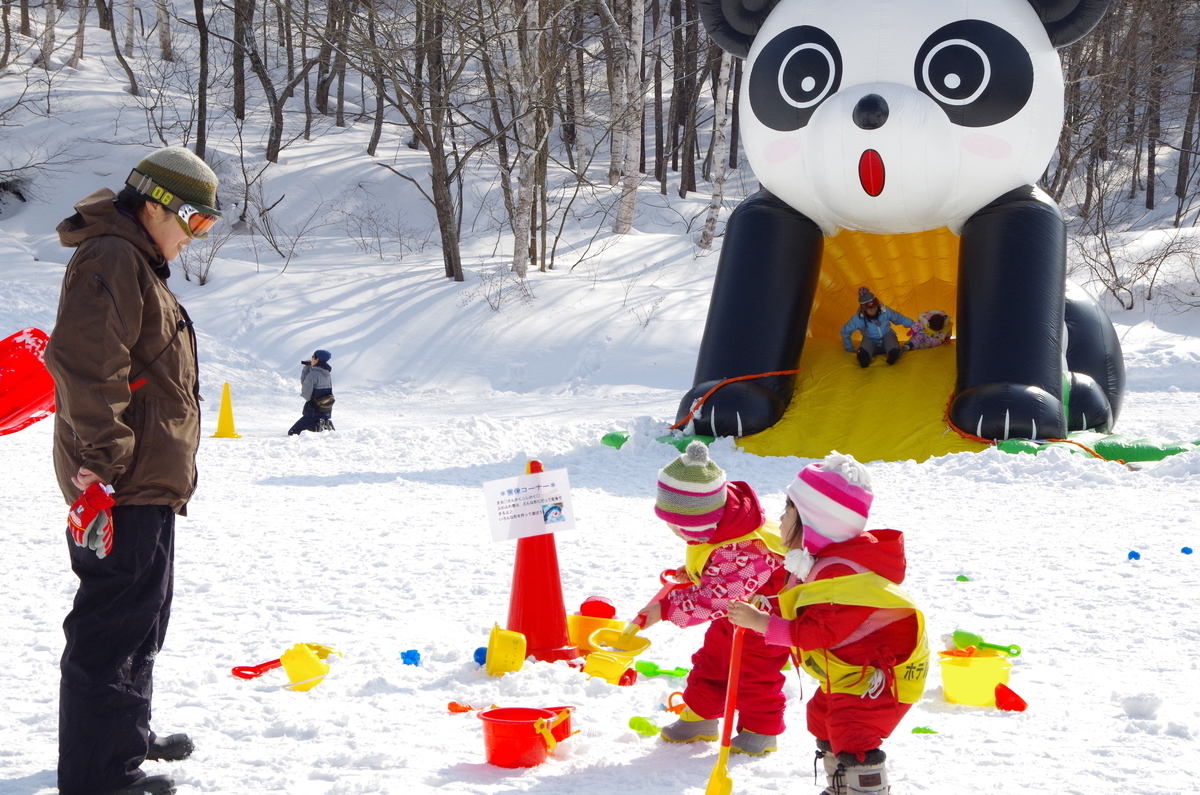 Minakami Kogen Fujiwara in Japan - a man standing next to a giant panda balloon.