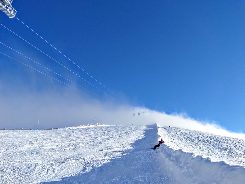 Jasná Nízke Tatry – Chopok in Slovakia - a person riding a ski lift in the snow.