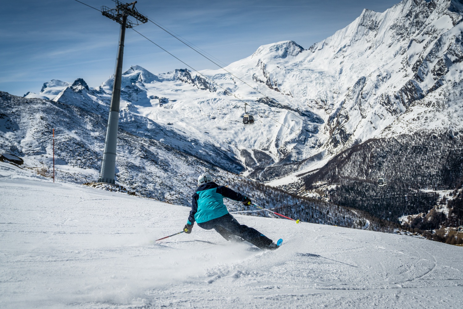 Saas Fee in Switzerland - a person riding a snowboard down a mountain.