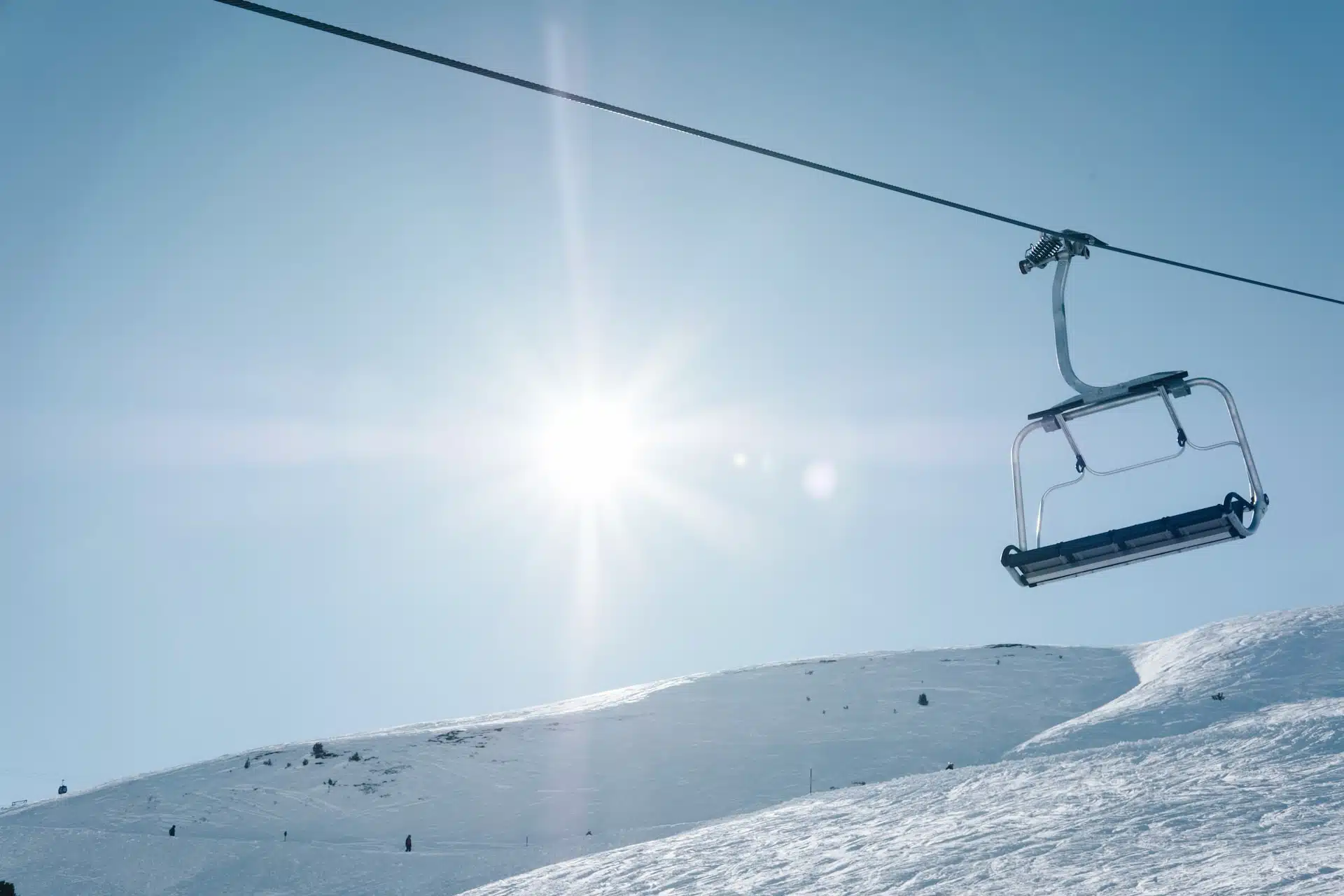 A skier enjoying a downhill run at Mt. Maichen Ski Hill in Watson Lake, Yukon, Canada. The scenic winter sports setting includes a ski lift, adding to the ambience of this bustling ski resort.