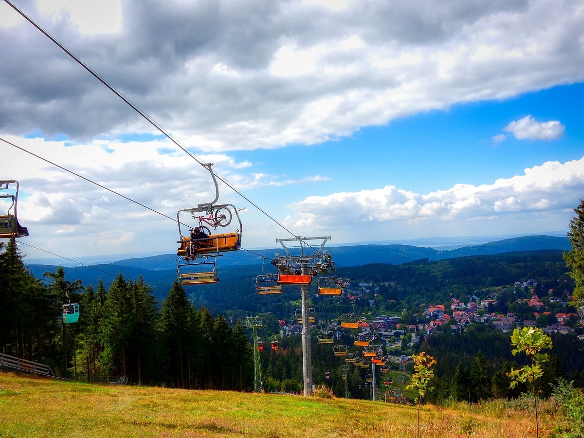 Bocksberg – Hahnenklee in Germany - a ski lift going up the mountain with a view of the city below.