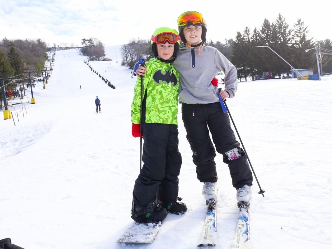 Mystic Mountain – Farmington in USA - two children are standing in the snow on skiboards.