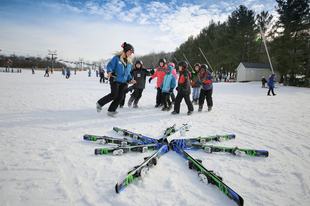 Mystic Mountain – Farmington in USA - a group of people standing on top of a snow covered field.
