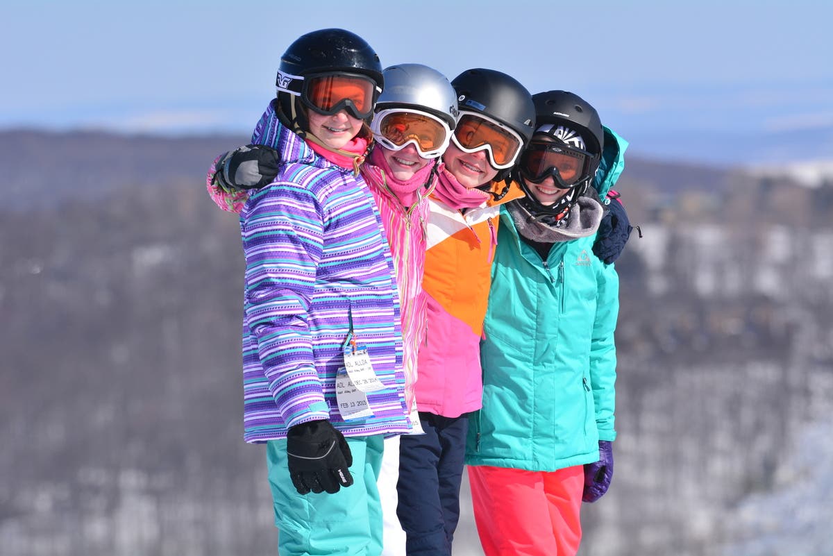 Mystic Mountain – Farmington in USA - three children standing on top of a snow covered hill.