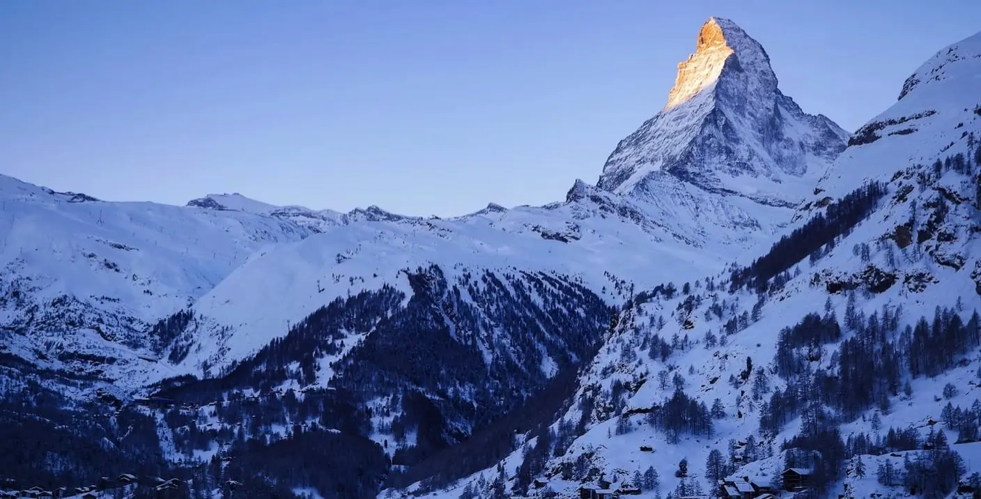 Bumbach in Switzerland - a mountain covered in snow at sunset.