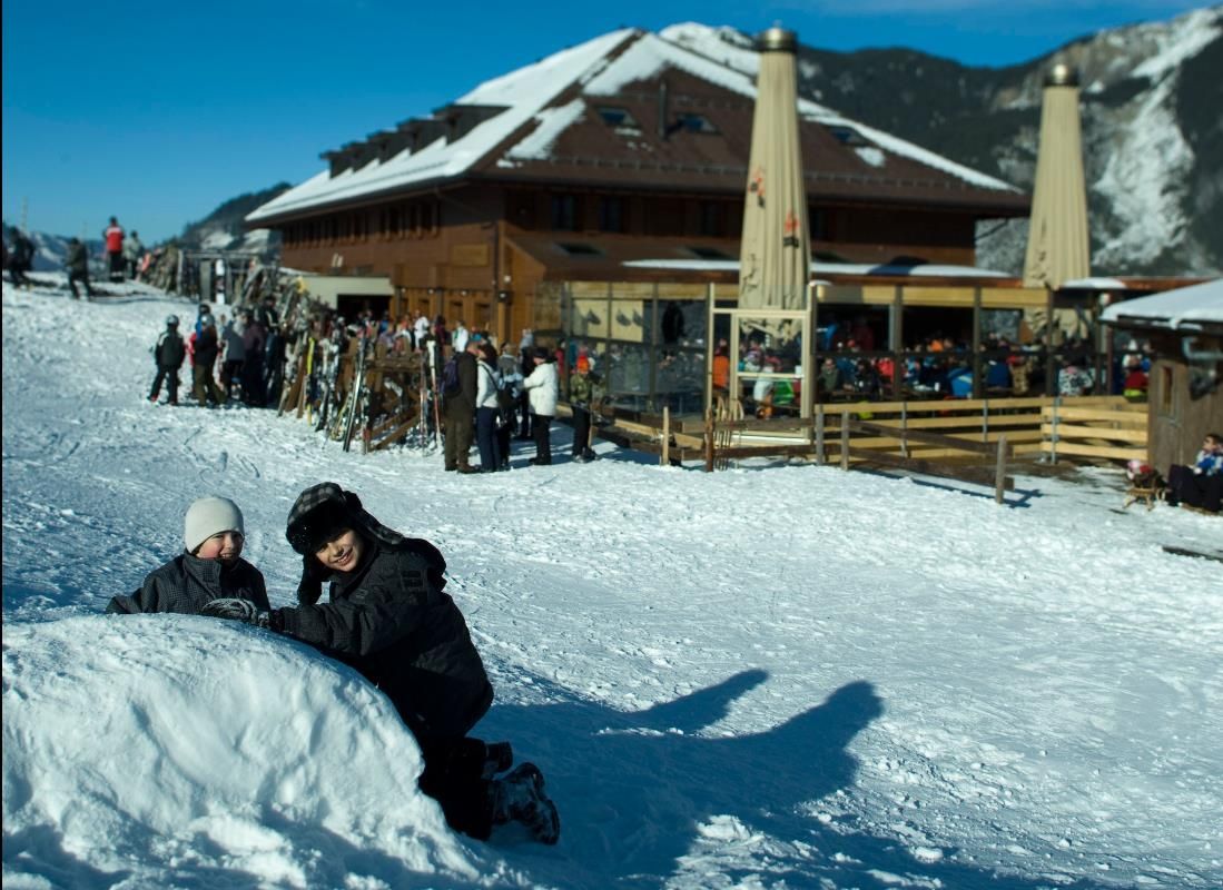 Bumbach in Switzerland: a person laying in the snow in front of a building.