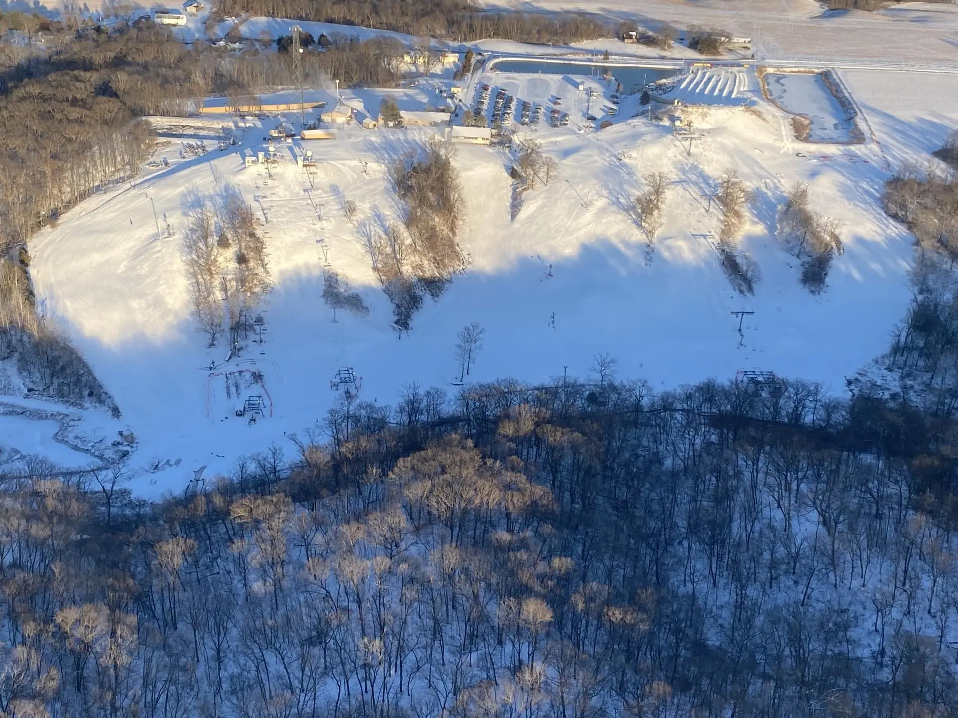 Looking at a ski resort at Snowstar in Illinois with snow-covered slopes and a mountain in the background. The scene captures the essence of winter sports amid stunning winter scenery.
