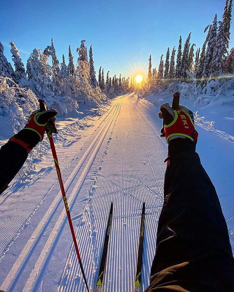 Nalovardo in Sweden - two people on skis in the snow at sunset.