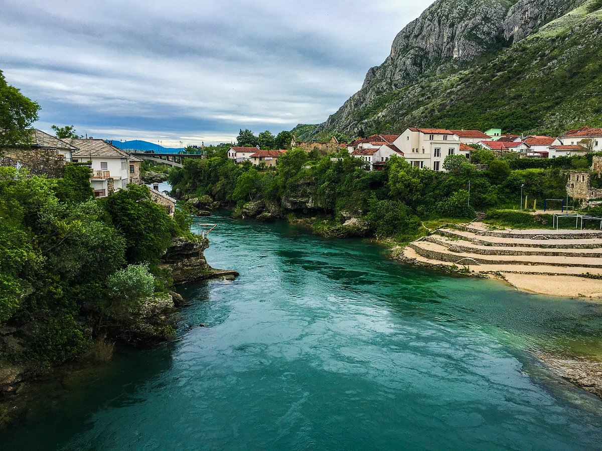 Vlašić in Bosnia and Herzegovina - a river runs through a small town surrounded by mountains.