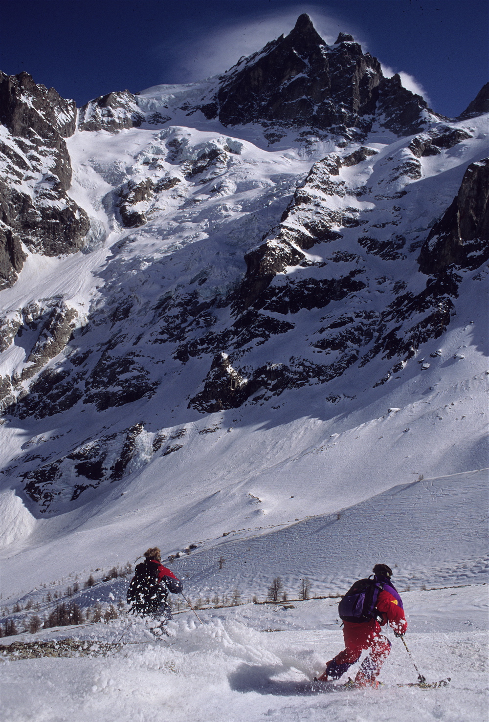 La Grave , La Meije in France - two people skiing down a snowy mountain.