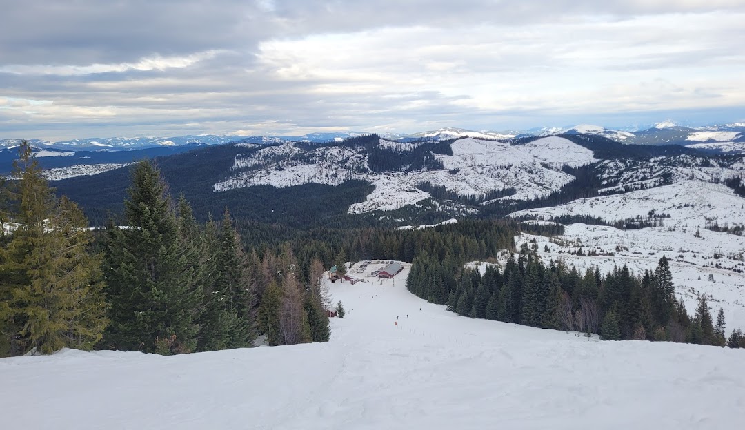 Winter sports scene at Bald Mountain ski resort in Idaho USA featuring a ski lift and a skier descending the snow-covered slopes.