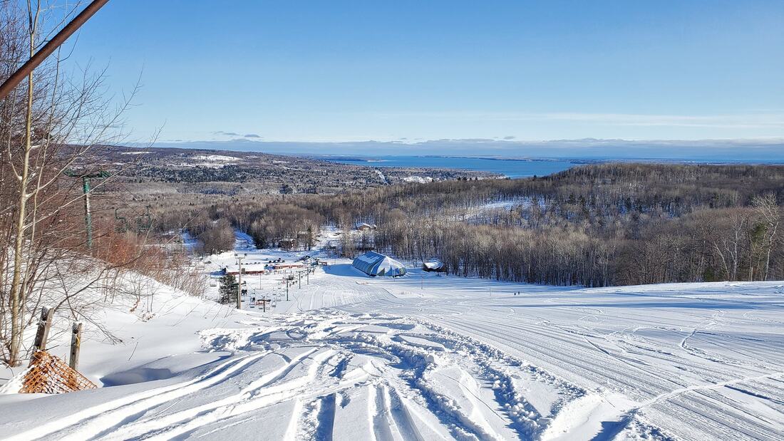 Winter sports enthusiasts enjoying the day at Mt Ashwabay – Salmo Ski Resort, nestled amidst the stunning winter scenery of Wisconsin, USA.
