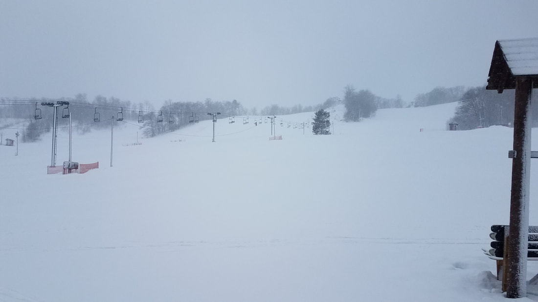 Winter sports enthusiasts enjoying at Mt Ashwabay – Salmo ski resort amidst stunning winter scenery, with a picturesque chalet in the background.