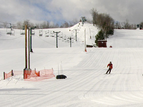 Skiers enjoying the winter sports scene at Mt Ashwabay–Salmo ski resort in Wisconsin USA complete with active ski lifts.