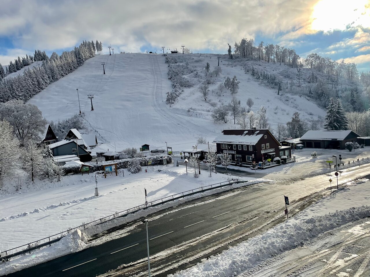 Matthias-Schmidt-Berg – St Andreasberg in Germany - a ski slope covered in snow with houses and trees.