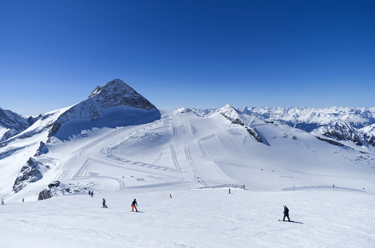 Hintertux Glacier in Austria - a group of people skiing down a snow covered mountain.