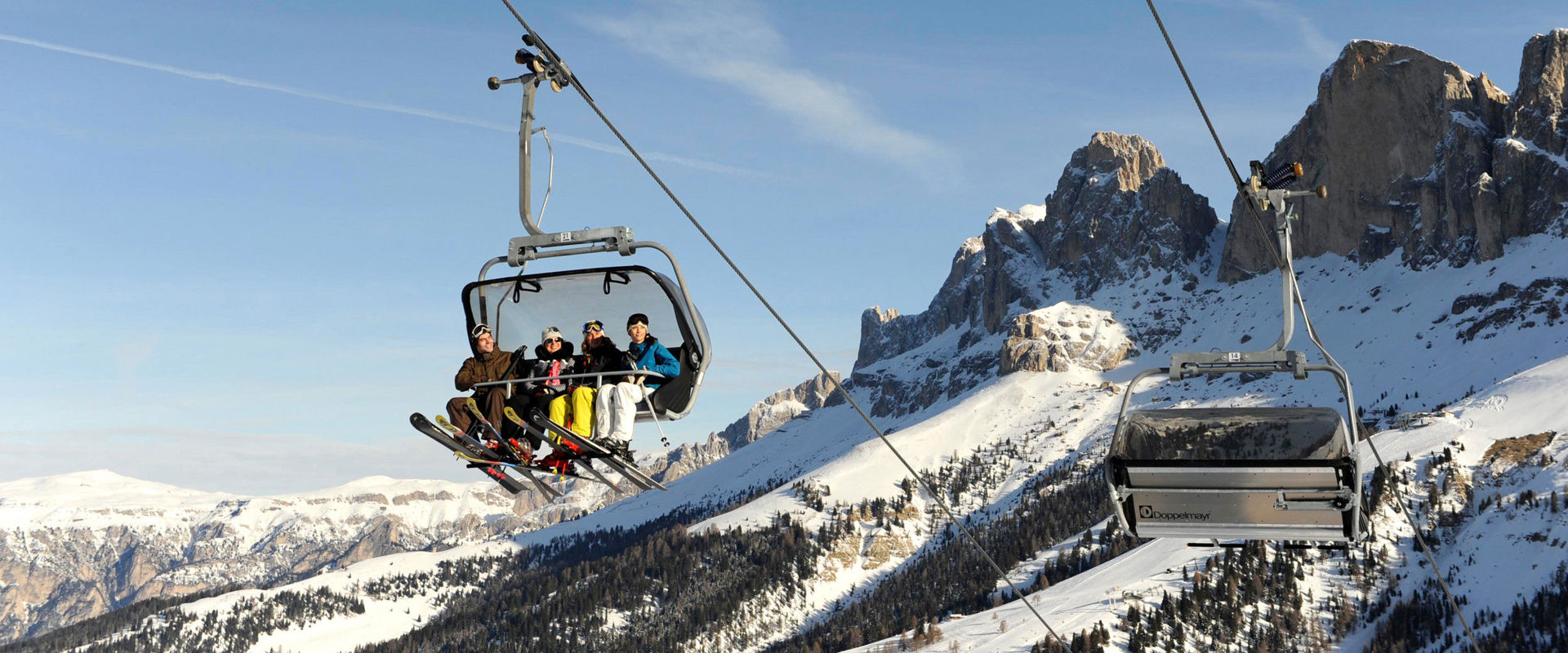 Carezza Dolomites in Italy - a couple of people riding a ski lift.