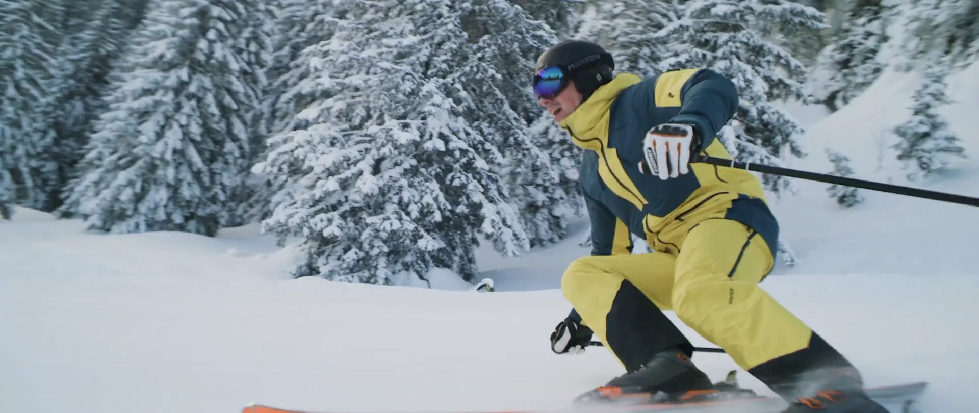 Reiserhang – Gaißach in Germany - a man in a yellow jacket skiing down a hill.