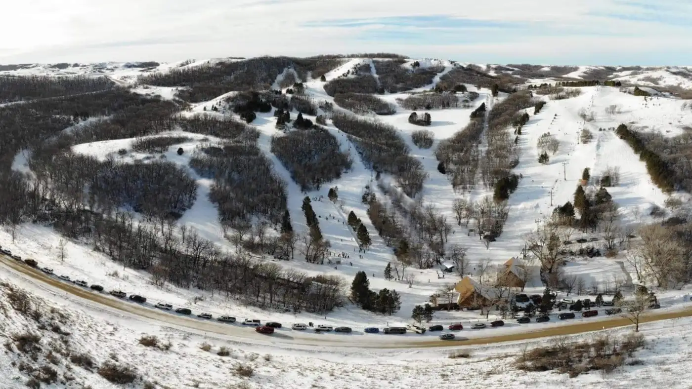 View of Huff Hills ski resort in Mandan, North Dakota displaying a winter sports scene with snow-covered slopes, ski lift, and stunning winter scenery.
