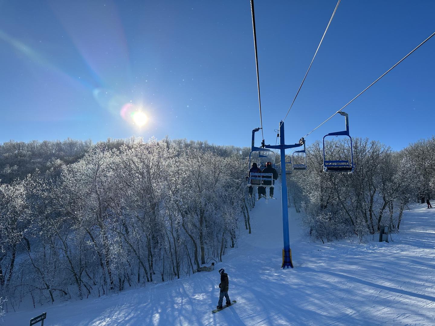 Huff Hills in USA - a person riding a ski lift in the snow.
