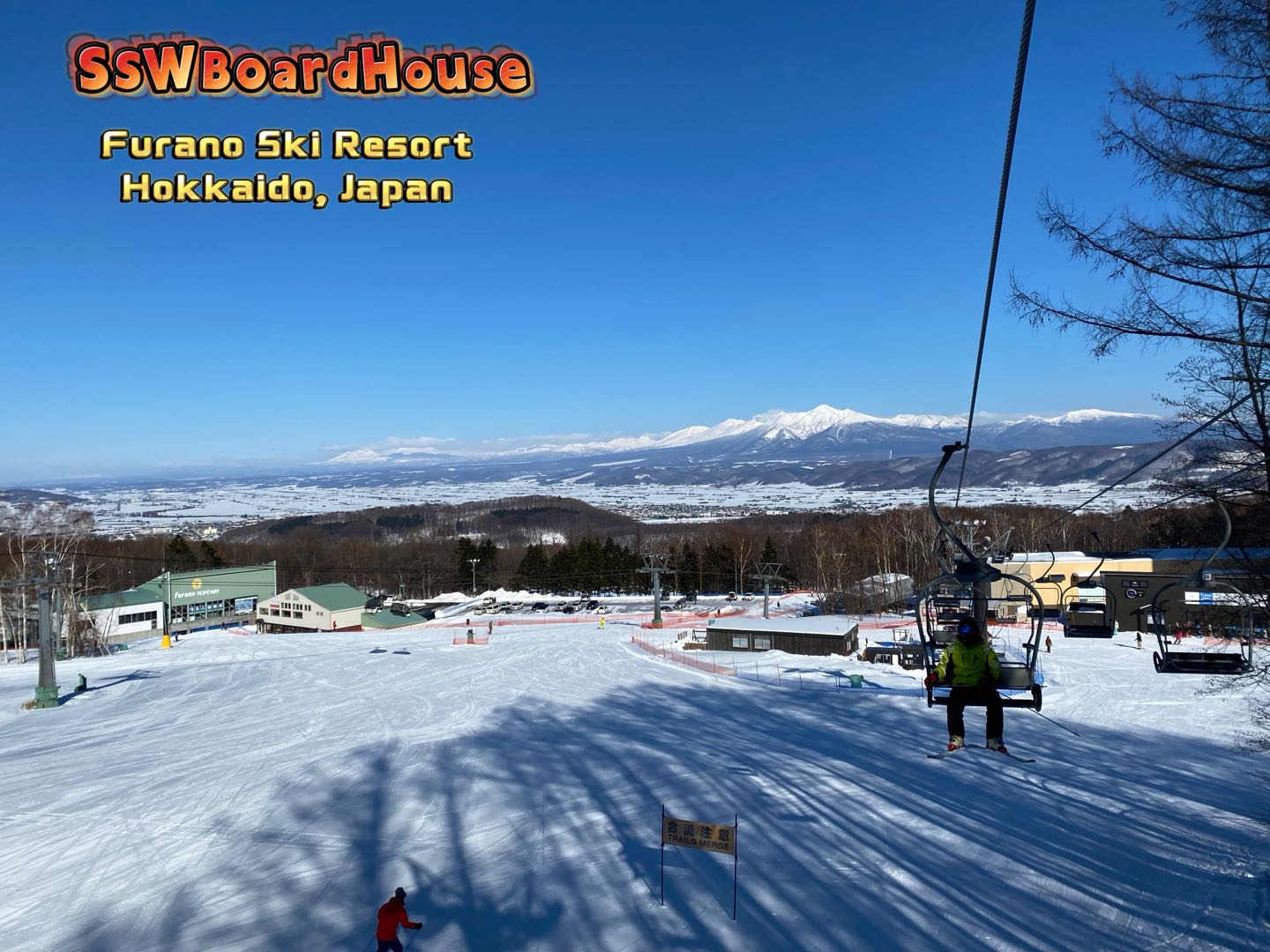 Furano in Japan - a ski slope with people skiing down it.