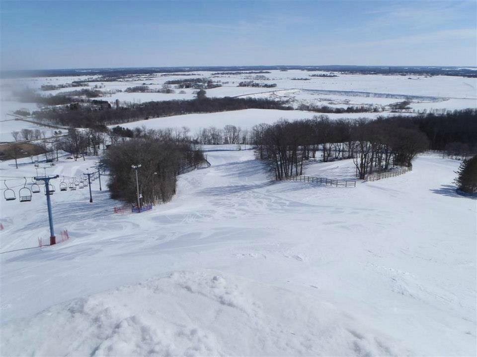 Winter sports enthusiasts enjoy a day on the snow-covered slopes at Powder Ridge, Minnesota. Scene features a skier and a ski lift on the scenic and serene ski resort.