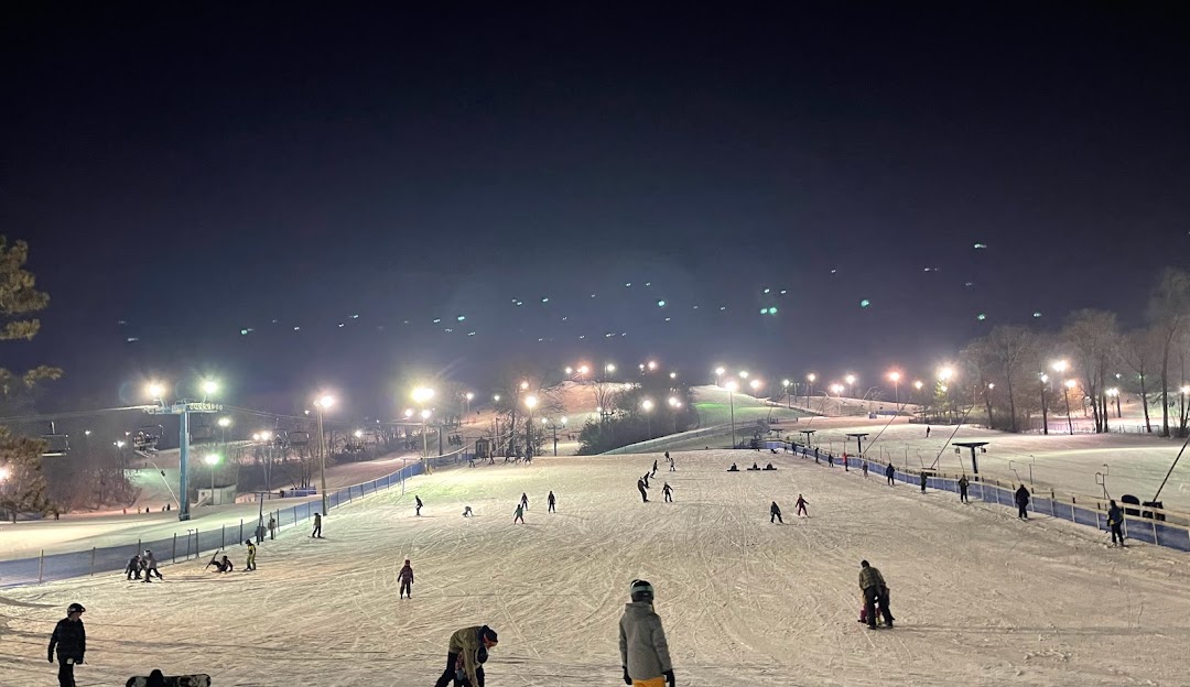 Winter sports enthusiasts enjoying a day at Powder Ridge, Minnesota, a ski resort highlighted by postcard-perfect winter scenery.