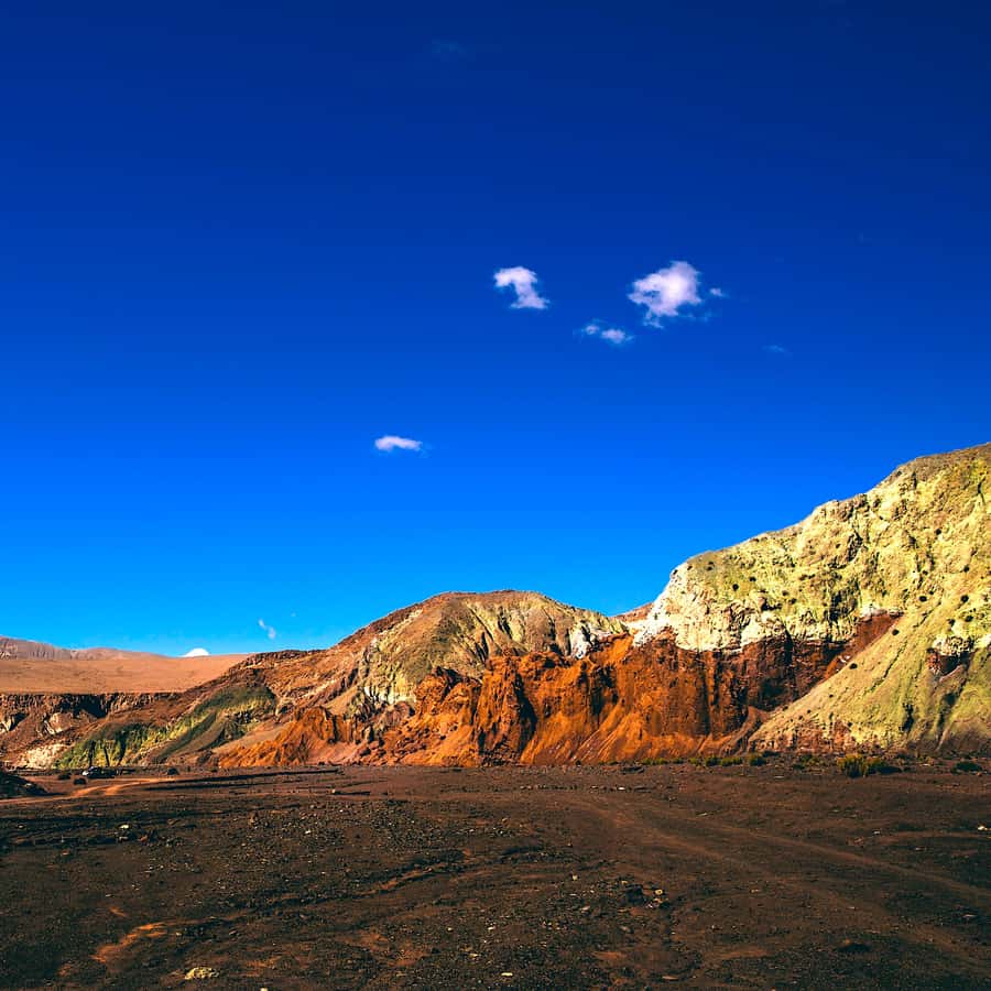 Rainbow Valley in New Zealand - a mountain with a blue sky in the background.