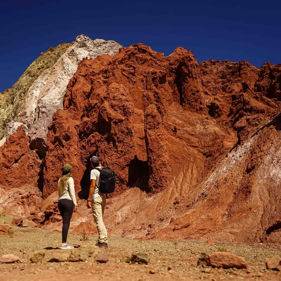 Rainbow Valley in New Zealand - two people standing in front of a mountain.