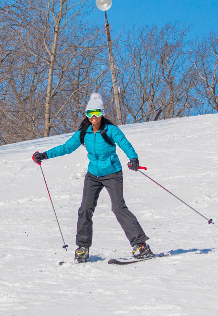 Wild Mountain in USA - a woman in a blue jacket skiing down a hill.