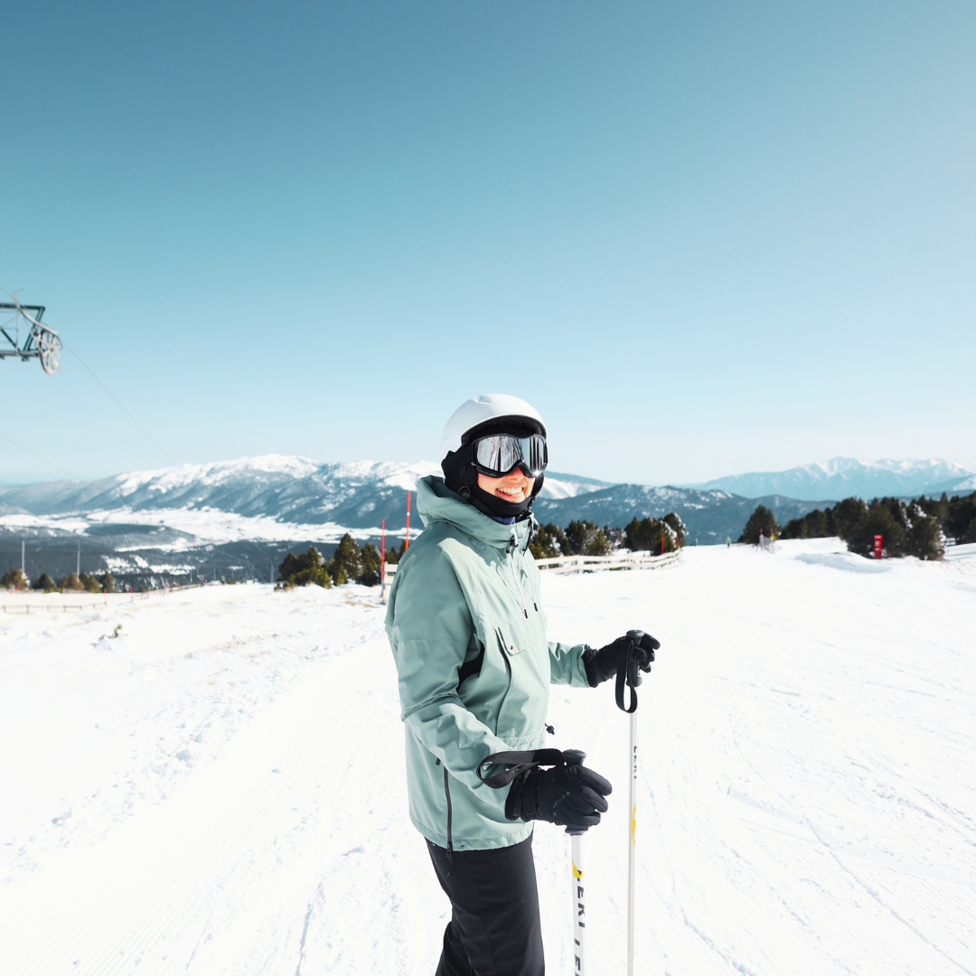 A skier gliding down a slope at Les Angles ski resort in France, with a snowboarder nearby. A ski lift is in the background, setting the scene of an active winter sports day.