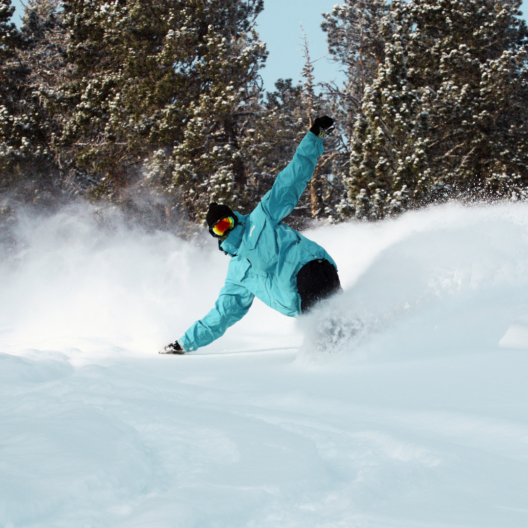 A snowboarder and skier are enjoying a sunny day on the powdery slopes of Les Angles a beautiful winter sports destination in Pyrénées-Orientales France.