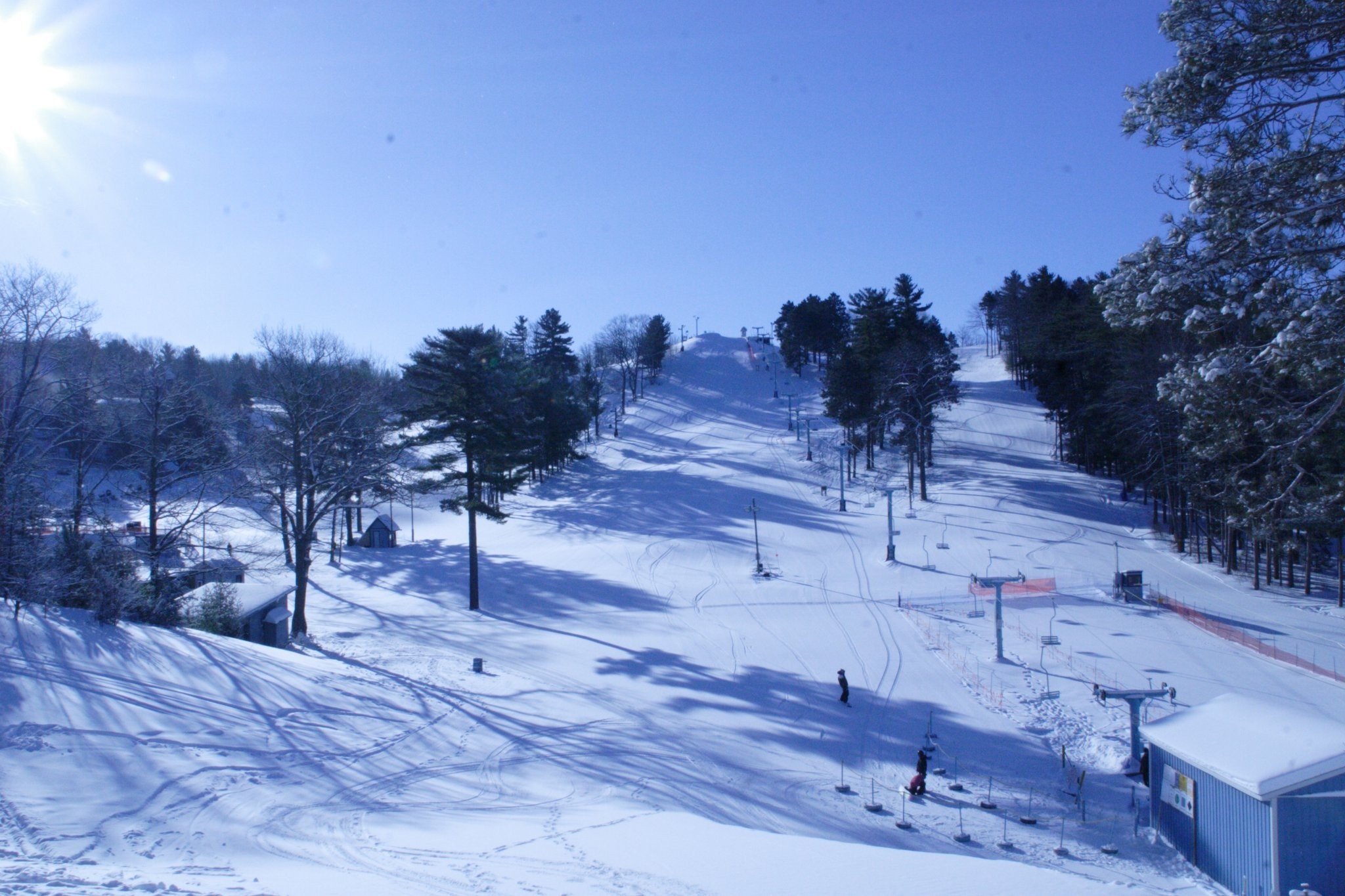 A winter sports scene at Mt Holiday in Michigan, USA, featuring stunning snow-covered landscapes. The scene includes a bustling ski resort and a charming chalet, encapsulating a festive winter sports centre atmosphere.