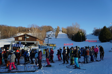Snow Valley – Barrie in Canada - a group of people standing on top of a snow covered slope.